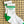 A pair of white crew socks with green and gray stripes and 'DALLAS' text laying on a patterned background. 