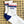 A pair of white crew socks with blue and red stripes and 'TEXAN' text laying on a patterned background. 