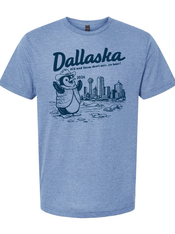 Light Blue t-shirt with a graphic of a penguin in front of the Dallas skyline and text reading "Dallaska" ICE and texas don't mix, ya hear?" 