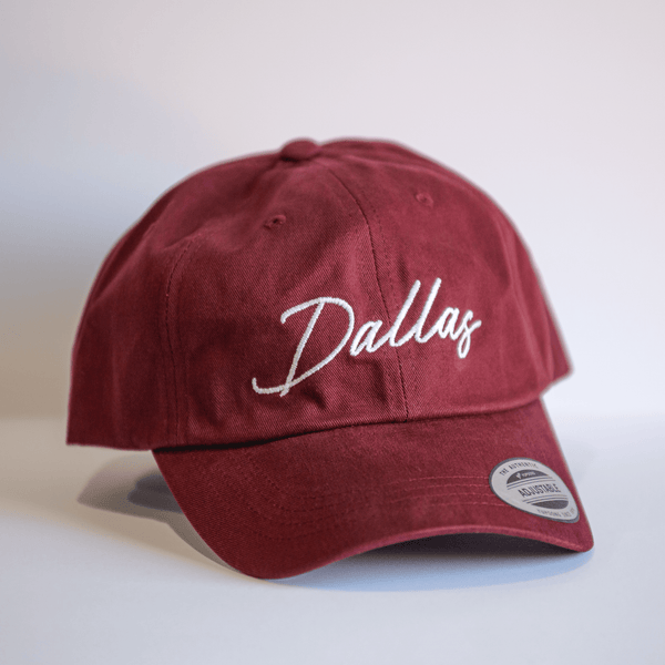 Embroidered Dallas Script Hat in maroon color, perfect for showing Texas pride. This stylish cap makes a great Texas themed gift, ideal for Texas Made Gifts enthusiasts and those looking for souvenirs from Texas, especially Dallas souvenirs and Texan gifts.