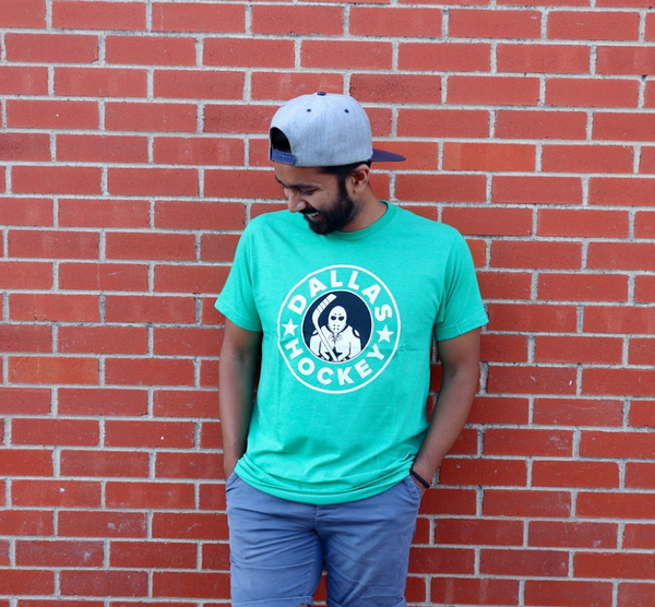 Photo of a man wearing the Bullzerk Dallas Hockey tshirt leaning against a brick wall. 
