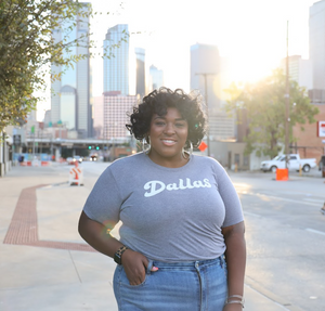 Photo of a woman standing outside in downtown Dallas wearing the Bullzerk Dallas Script tshirt. 