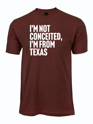 Maroon T-shirt featuring the phrase 'I'M NOT CONCEITED, I'M FROM TEXAS', perfect for showcasing Texas pride. This stylish tee makes a great Texas themed gift, ideal for souvenir lovers and anyone seeking Texas Made Gifts, Dallas souvenirs, or unique Texan gifts.