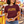 Woman wearing maroon Hot Girls Eat Corny Dogs T-shirt at a fair food stand, holding corny dogs
