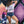 Woman standing in front of a mural, holding a skateboard and wearing a Bullzerk 