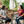 Two women sitting at an outdoor table, one drinking from a glass, the other engaged in conversation, both wearing Bullzerk tshirts.