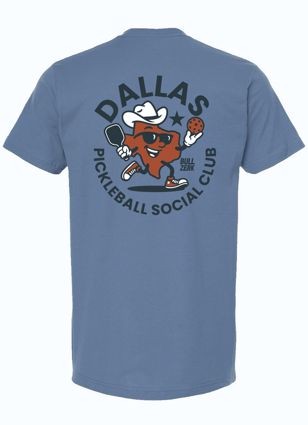 Back view of a slate blue tshirt featuring a graphic design of a Texas-shaped character wearing sunglasses and a cowboy hat playing pickleball. The character is surrounded by a circle of text reading "DALLAS PICKLEBALL SOCIAL CLUB" in navy letters. 