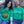 Two people wearing green Bullzerk St. Patrick's Day tshirts with humorous designs, sitting outdoors.