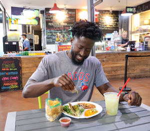 Man eating a plate of tacos, wearing the Bullzerk Tacos tshirt.