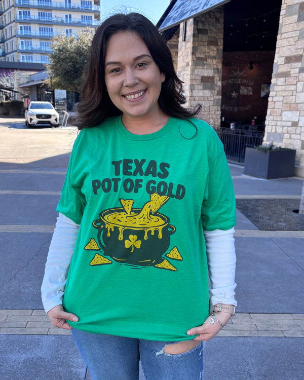 Woman wearing a Bullzerk "Texas Pot of Gold" tshirt, standing outside by a restaurant. 