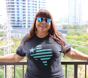 Woman wearing a Bullzerk Texas Silhouette tshirt standing outside. 