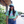 Woman wearing the Bullzerk Tie Dye Texas Silhouette tshirt with sunglasses and a baseball hat, standing outside near flowers. 