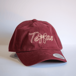 Embroidered Texas Bow Hat in maroon, perfect for showing your Texas pride. This stylish cap is a great Texas themed gift, ideal for anyone who loves Texas Made Gifts, and makes a fantastic souvenir from Texas. Perfect for a dallas souvenir or any Texan gifts collection.