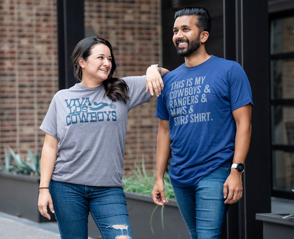Two people wearing Bullzerk cowboys tshirts, standing outdoors.