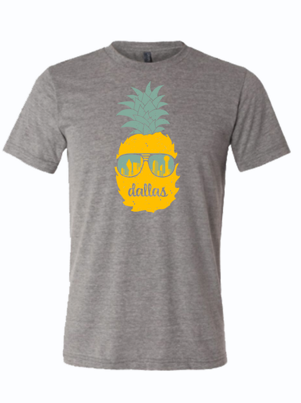 Dallas Pineapple T-shirt featuring a vibrant pineapple design with sunglasses, perfect for summer wear. This shirt is a great Texas themed gift, ideal for those looking for Texas Made Gifts, souvenirs from Texas, and a fun dallas souvenir. It's a must-have for anyone who loves texan gifts.