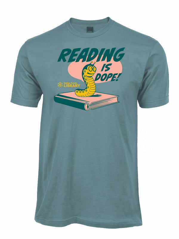 The 'Reading Is Dope' tee features a playful caterpillar on a book, perfect for book lovers. Show your support for the Dallas Public Library with this Texas themed gift. Ideal as a Texas Made gift, this t-shirt makes a great souvenir from Texas, adding charm to any Texan's wardrobe while promoting literacy.
