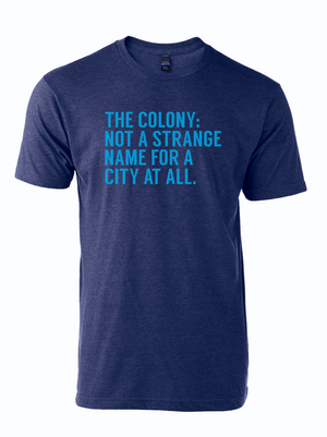 A unisex tri-blend t-shirt featuring the phrase 'The Colony: Not A Strange Name for A City At All' in bold aqua lettering. This stylish shirt makes a great Texas themed gift and is perfect as a Dallas souvenir. Ideal for anyone looking for unique Texan gifts or Texas Made Gifts, celebrating local pride.